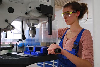 Rebecca wird Elektronikerin Frau mit Schutzbrille, von der Seite fotografiert